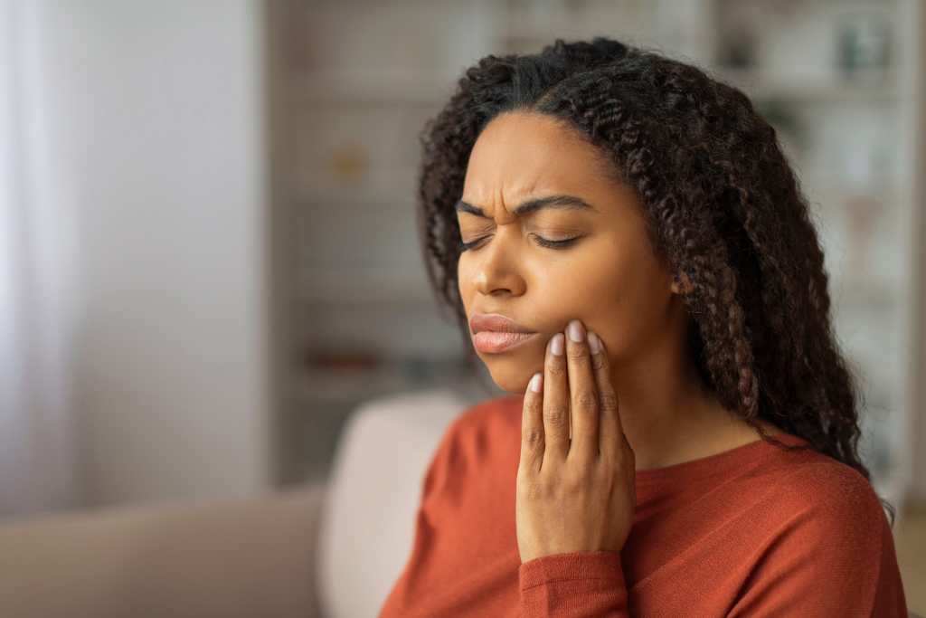 young black woman pressing her cheek